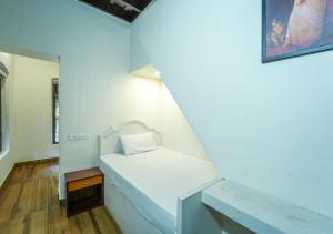 a small bed in a room with a mirror at Pop Tavern Private Pool Villa Kovalam by VOYE HOMES in Kovalam +81 photos