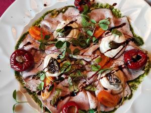 a plate of food with meat and vegetables on it at Pension Alpenblick in Vipiteno