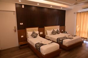 a bedroom with two beds and a window at Grand Cascade Chennai in Chennai