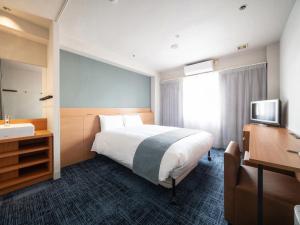 Vessel Hotel Kurashiki في كوراشيكي: غرفة الفندق بسرير ومغسلة