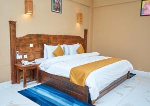 a bedroom with a large bed with a wooden headboard at Sogakope Beach Resort & Spa in Sogakofe