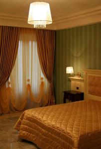 格羅塔米納爾達的住宿－里賈納迪薩巴酒店，一间卧室配有一张床和一个吊灯