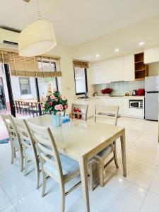 a kitchen and dining room with a wooden table and chairs at Vila Lotus Hạ Long in Ha Long