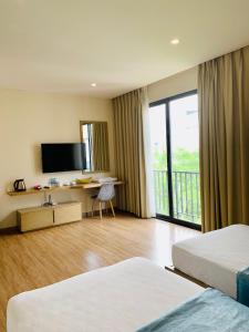 a hotel room with two beds and a television at Vila Lotus Hạ Long in Ha Long
