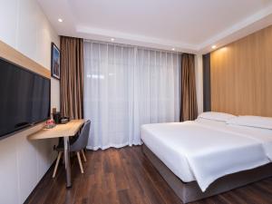 Country Inn&Suites by Radisson, Shanghai PVG في شانغهاي: غرفة نوم بسرير ومكتب وتلفزيون