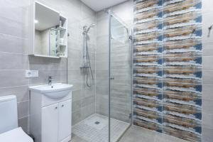 a bathroom with a shower and a toilet and a sink at Amber - Luxury Two Bedroom Apartment in Palanga +24 photos