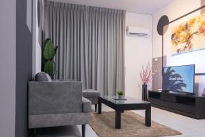 ein Wohnzimmer mit einem Stuhl und einem TV in der Unterkunft Staycation Homestay 39 MJC Upper Sanctuary Resorts At Batu Kawa in Kuching