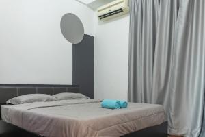 ein Schlafzimmer mit einem Bett und einem blauen Handtuch darauf in der Unterkunft Staycation Homestay 39 MJC Upper Sanctuary Resorts At Batu Kawa in Kuching