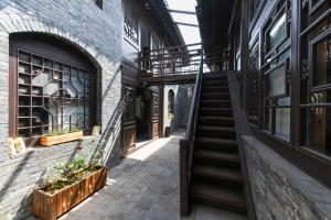平遙的住宿－Elsewhere Xianya Hotel ，楼梯和植物的楼宇中的小巷