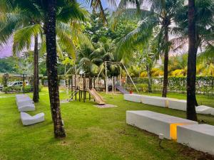 a playground in a park with palm trees at By The Sea, Penang in Batu Ferringhi