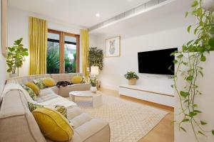 a living room with a couch and a flat screen tv at The Bronte Breeze in Sydney