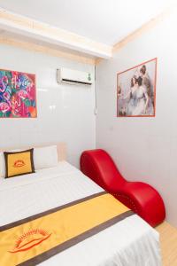 1 dormitorio con 1 cama y 1 silla roja en Motel Hoài An en Can Tho