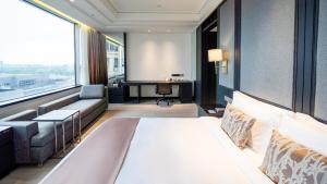 um quarto de hotel com uma cama grande e um sofá em Crowne Plaza Shanghai Anting, an IHG Hotel - 15 minutes drive to FE em Jiading