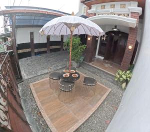 einen Overhead-Blick auf einen Tisch mit einem Regenschirm in der Unterkunft Griya Giwangan Homestay Jogja in Timuran