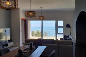 a living room with a couch and a view of the ocean at Sunset View 23 in Langstrand