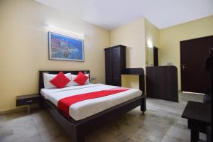 1 dormitorio con 1 cama con almohadas rojas en OYO 24408 Nirmala Guest House, en Jodhpur