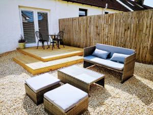 a patio with a chair and ottoman and a table at Harling House in Prestwick