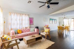 Una sala de estar con un sofá rosa y una mesa. en Pink Lemonade, en Desert Hot Springs