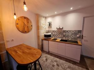 een keuken met een tafel en een klok aan de muur bij Le St Gildard in Nevers