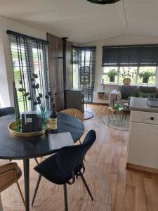 a kitchen and living room with a table and chairs at Camping 't Venhop in Berkhout
