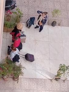 a group of people sitting on a sidewalk next to plants at Majorelle Family Residence Medina in Marrakech
