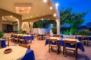 a restaurant with tables and chairs in a courtyard at night at Saint Amon Hotel in Faliraki