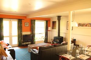 a living room filled with furniture and a tv at Merrimeet Cottages in Bright