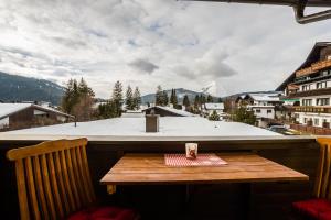 kubek kawy na drewnianym stole na balkonie w obiekcie Appartement Amalie by MoniCare w mieście Seefeld in Tirol