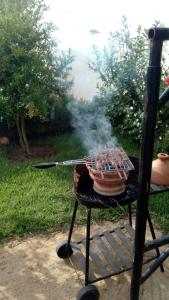 Ein Grill mit Rauch aus dem Grill in der Unterkunft Charmante maison de campagne in Temara