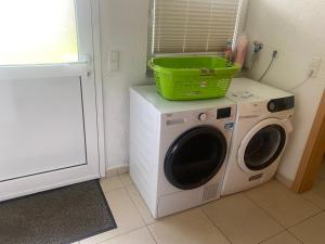 una lavadora con una cesta verde encima en Ferienzimmer Oelhaf Zimmer in Grau Self Check-In mit Key Tresore, en Wilhelmsdorf