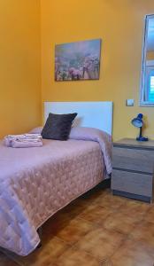 a bedroom with a bed and a dresser with a lamp at Casa Carballa in Os Muinos