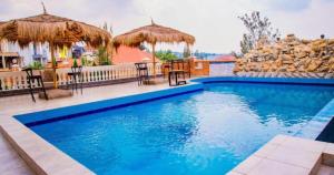 - une piscine avec des chaises longues et des parasols dans l'établissement The Keza Hotel, à Kigali