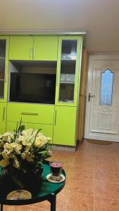 a green cabinet with a vase of flowers on a table at Casa Carballa in Os Muinos