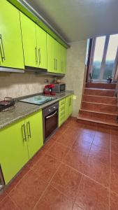 a kitchen with lime green cabinets and a tile floor at Casa Carballa in Os Muinos