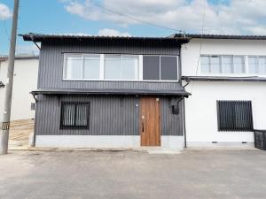 Casa en blanco y negro con puerta de madera en IZUMO DOGS - Vacation STAY 14434v en Izumo
