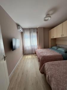 a hotel room with two beds and a window at Orange Apartment in Golem +86 photos