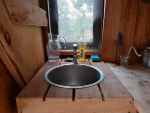 a sink in a wooden room with a window at JP's A frame cabin in Fort Portal