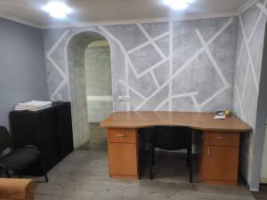 una oficina con un escritorio de madera y una pared con un arco en Small Home, en Chişinău