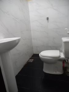 ein Badezimmer mit einem weißen WC und einem Waschbecken in der Unterkunft Sun Rest Colombo in Colombo