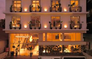a large white building with lights on the balconies at Minimalist Panjim in Marmagao