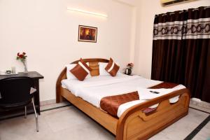 um quarto com uma cama e uma secretária num quarto em Hotel Sunshine I Couple Friendly I Budget Friendly em Gurgaon