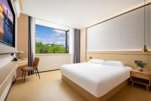 Habitación de hotel con cama y ventana en MISONG Light Residence Design Hotel - Shangrao Wuyuan Landscape Bridge en Wuyuan