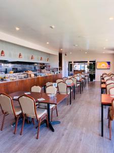 a dining room with tables and chairs and a restaurant at Airport Gateway Hotel in Auckland