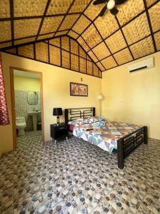 - une chambre avec un grand lit et une salle de bains dans l'établissement Bamboo Paradise Beach Resort, à Argao