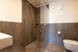 uma casa de banho com um chuveiro e um WC. em Platterhof em Tirolo