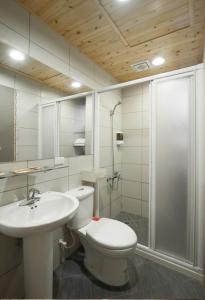 a bathroom with a toilet and a sink and a shower at Miss You House in Taichung