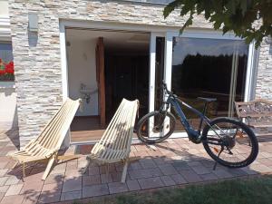 un vélo garé à côté de deux chaises sur une terrasse couverte dans l'établissement Haloze ForMe, à Zavrč