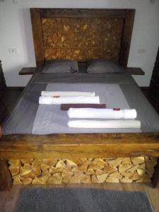 - un lit avec une tête de lit en bois et des serviettes dans l'établissement Haloze ForMe, à Zavrč
