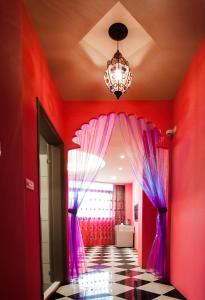 a red room with a chandelier and pink curtains at Miss You House in Taichung