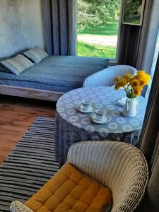 um quarto com uma mesa e uma cama e uma mesa com flores em Mellene 1 bedroom house in nature & hot tube em Turaida